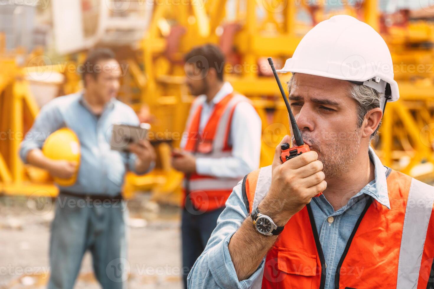 Italian worker engineer construction site control radio operation. Foreman operate crane tower working order by walkie talkie. photo