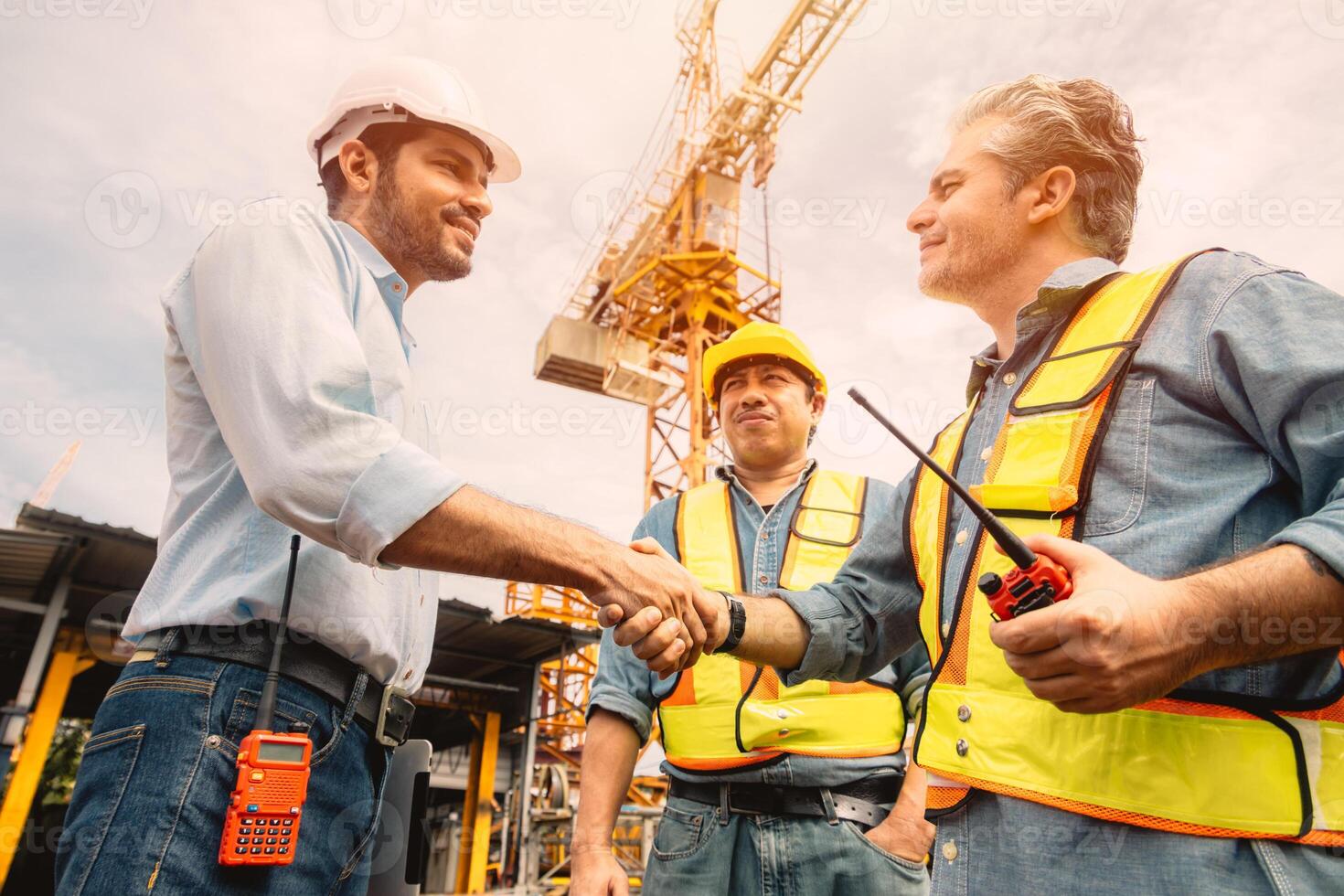 Workers team hand shaking deal with contractor happy at construction site. Engineer project business contact connection people concept. photo