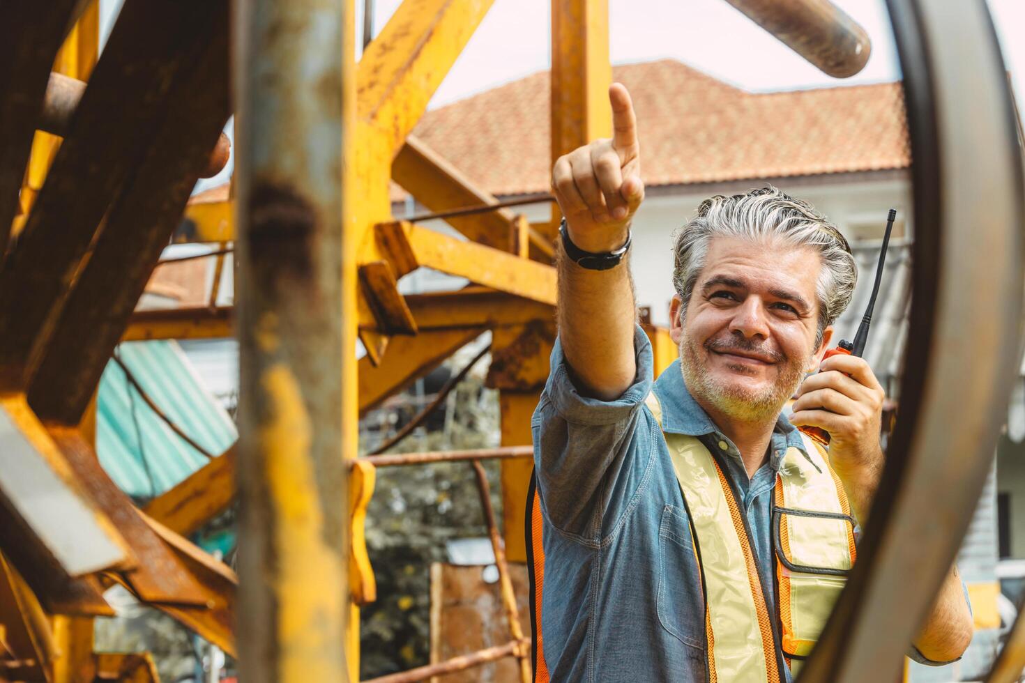 Italian worker engineer construction site control radio operation. Foreman working crane working order by walkie talkie. Happy worker portrait. photo
