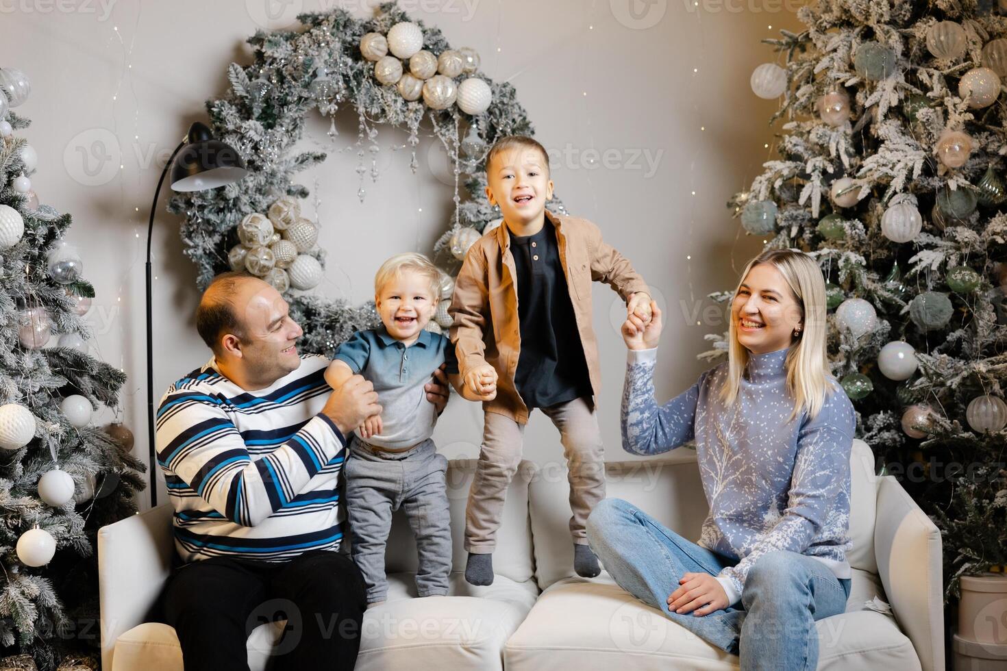 Family enjoys christmas morning, opening presents and laughing together photo