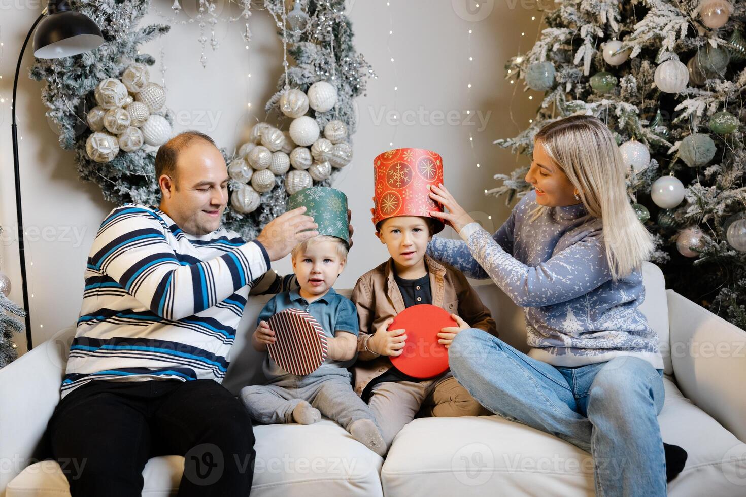 Family enjoys christmas morning, opening presents and laughing together photo