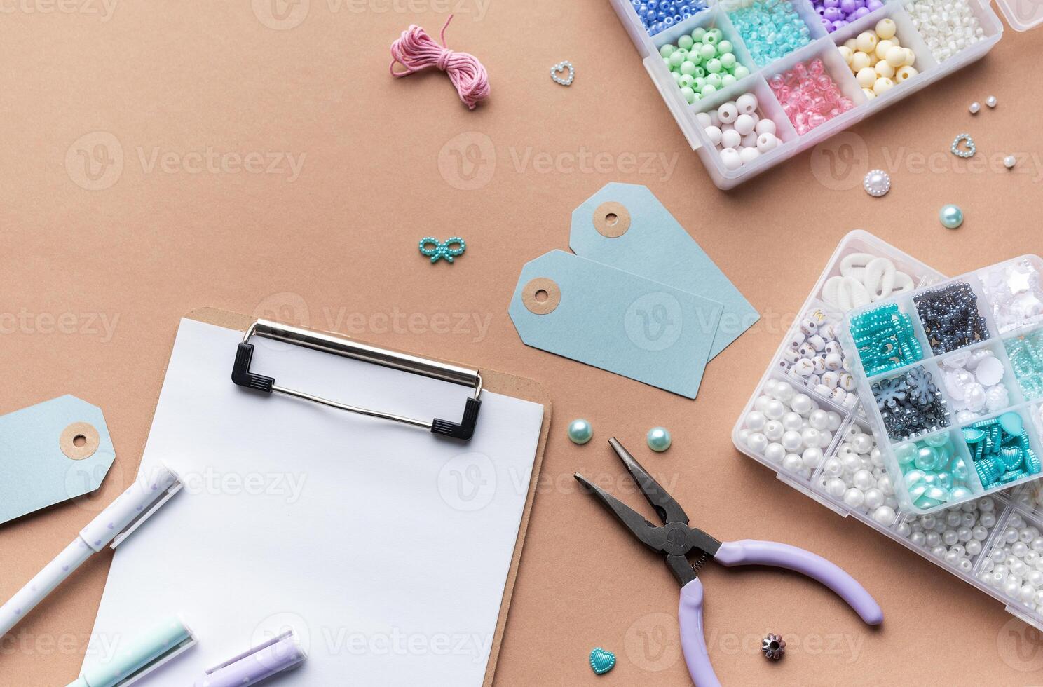 Crafting supplies arranged on a workspace with beads, tools, tags for personalized jewelry making photo
