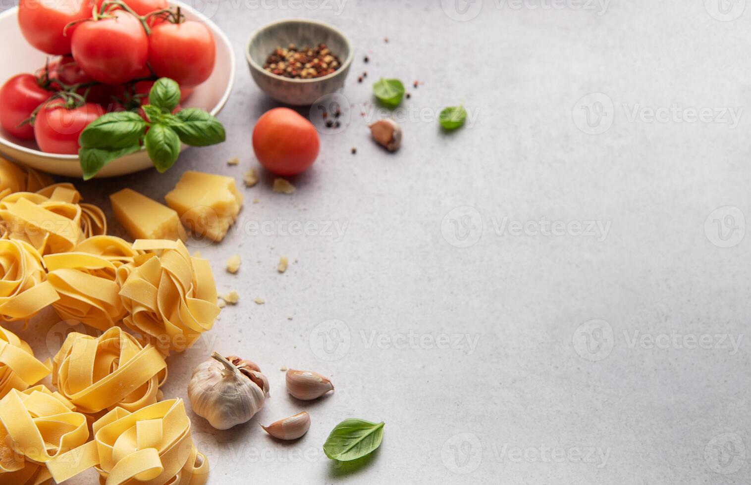 italiano pasta tagliatelle nido con Tomates, parmesano y ajo en gris antecedentes foto