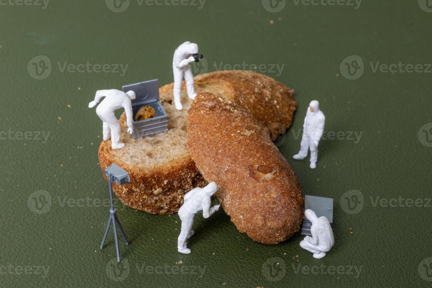 Miniature figurines dressed as forensic investigators examining bread slices with equipment photo