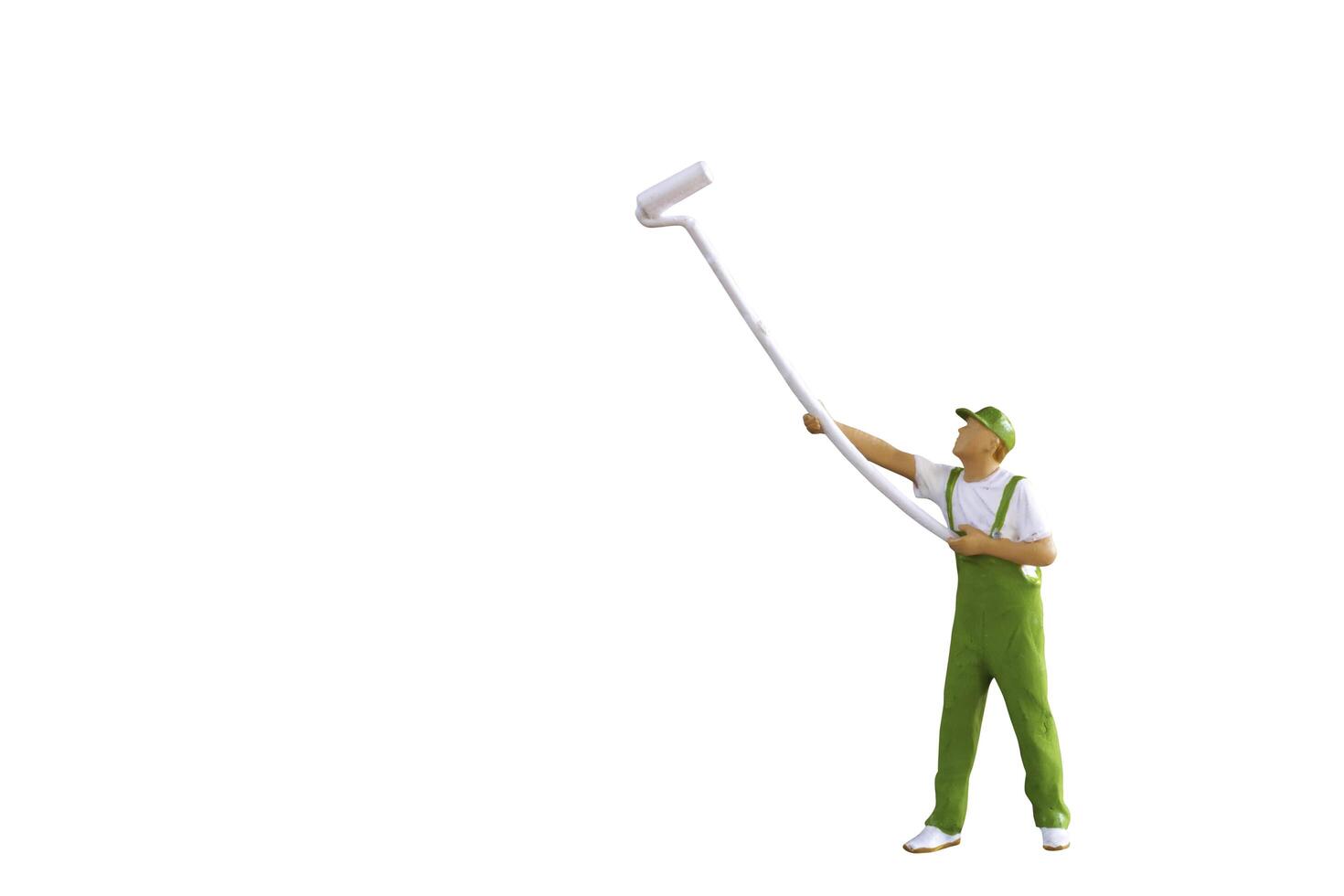 A miniature figurine of a painter holding a long-handled roller brush, isolated on white background with clipping path photo