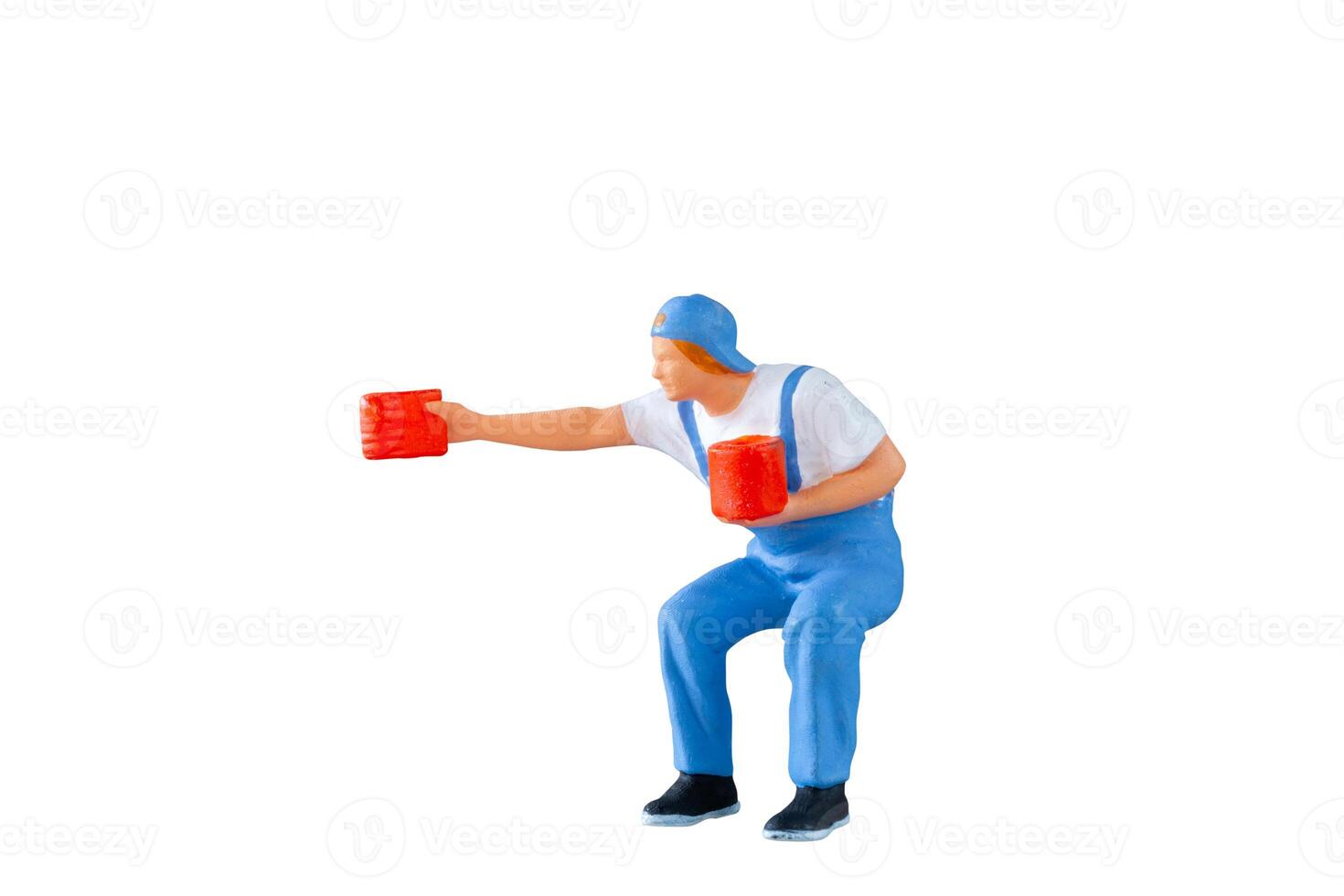 A miniature figurine of a painter holding a paint can and brush isolate on white background with clipping path photo