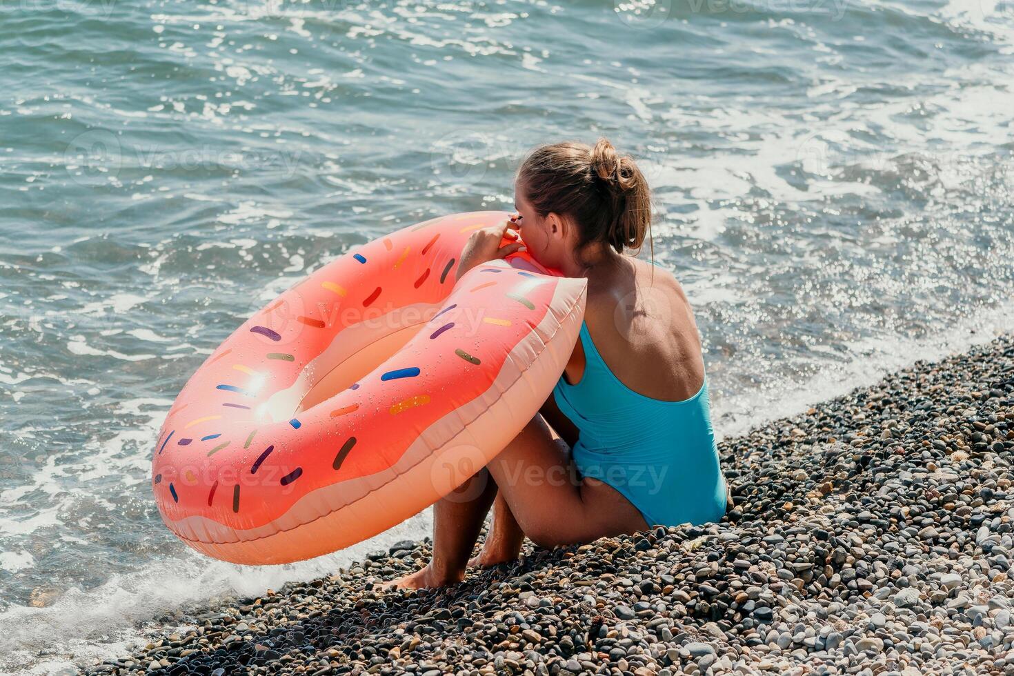 Summer Relaxation on a Pebble Beach with a Donut Float photo