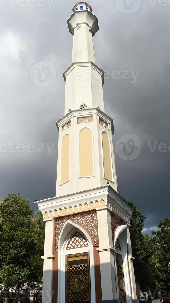 A beautiful tall mosque minaret against overcast sky photo