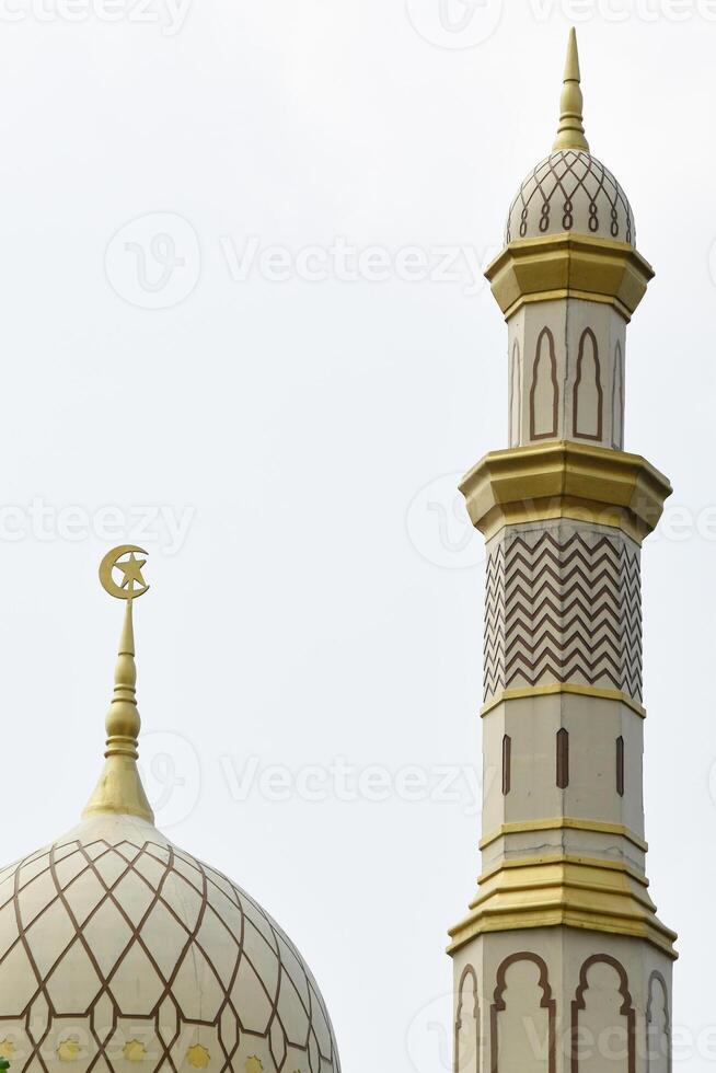 Beautiful mosque dome and minaret with white and gold colors photo