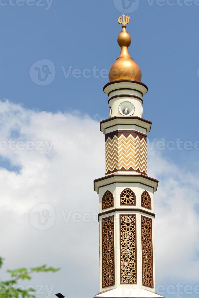 Tall mosque minaret with gold theme photo