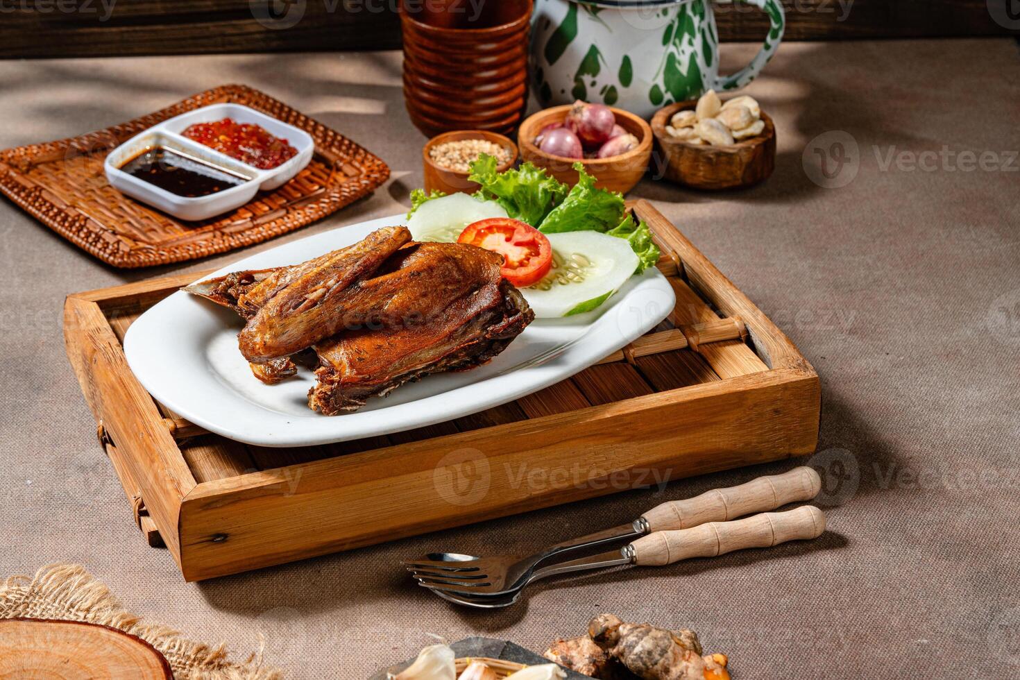 Bebek Goreng, Traditional Fried Duck. Popular Menu came from Madura, East Java. served with sambal, cucumber, tomato and lettuce. photo