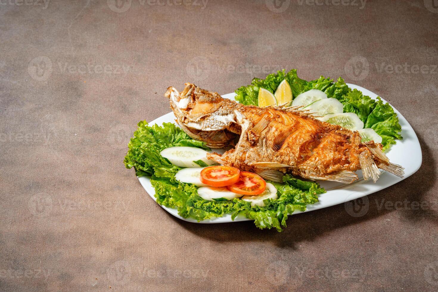 Deep fried crispy grouper fish with sambal dabu dabu photo