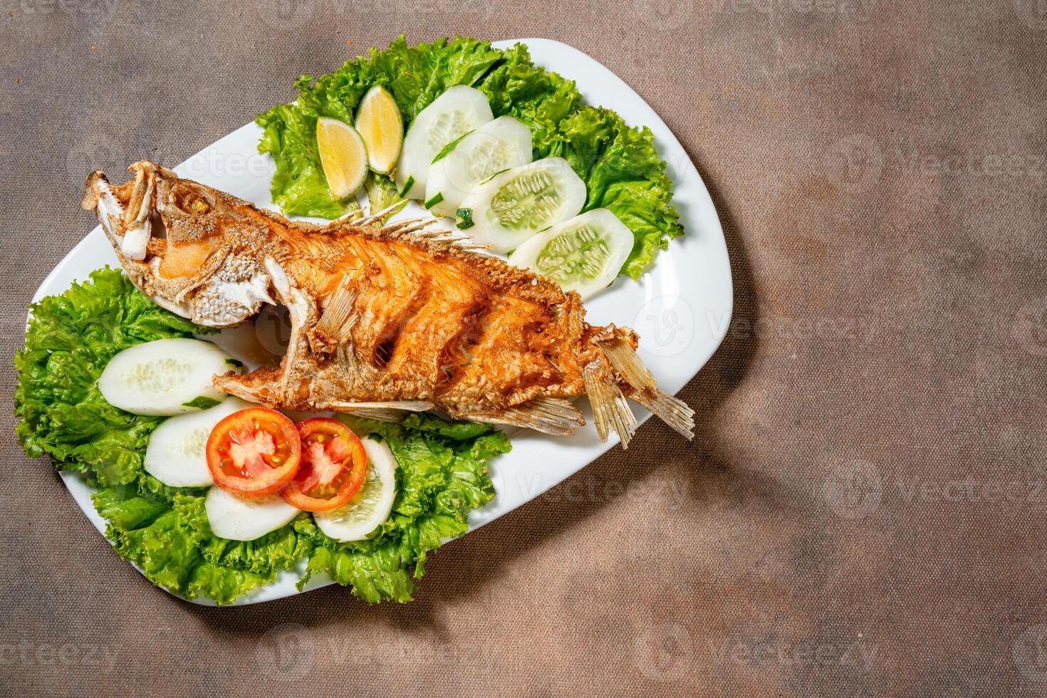 Deep fried crispy grouper fish with sambal dabu dabu photo