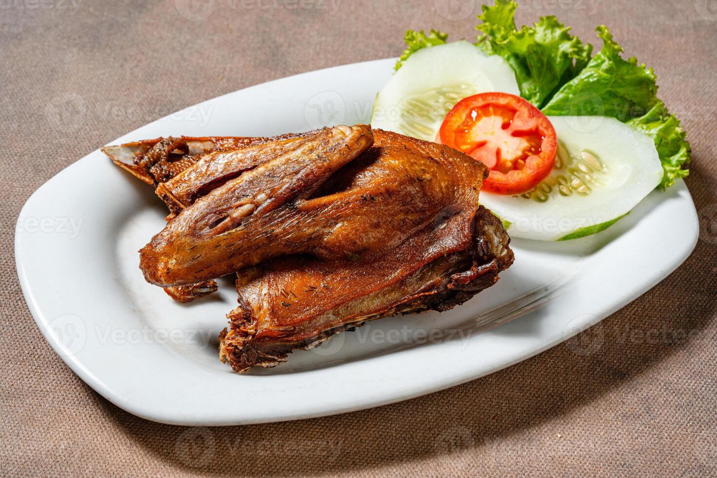 Bebek Goreng, Traditional Fried Duck. Popular Menu came from Madura, East Java. served with sambal, cucumber, tomato and lettuce. photo