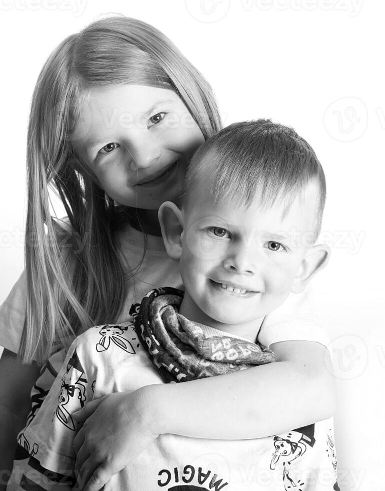 sister and brother smile and hug on a light white background photo