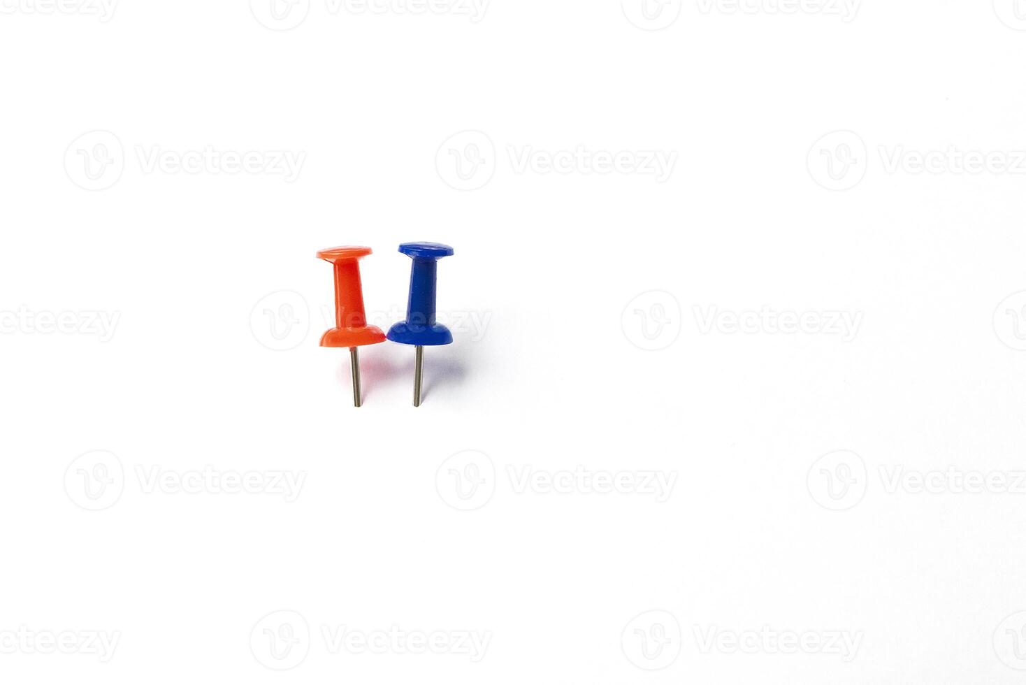 two different colorful push pins on white background photo