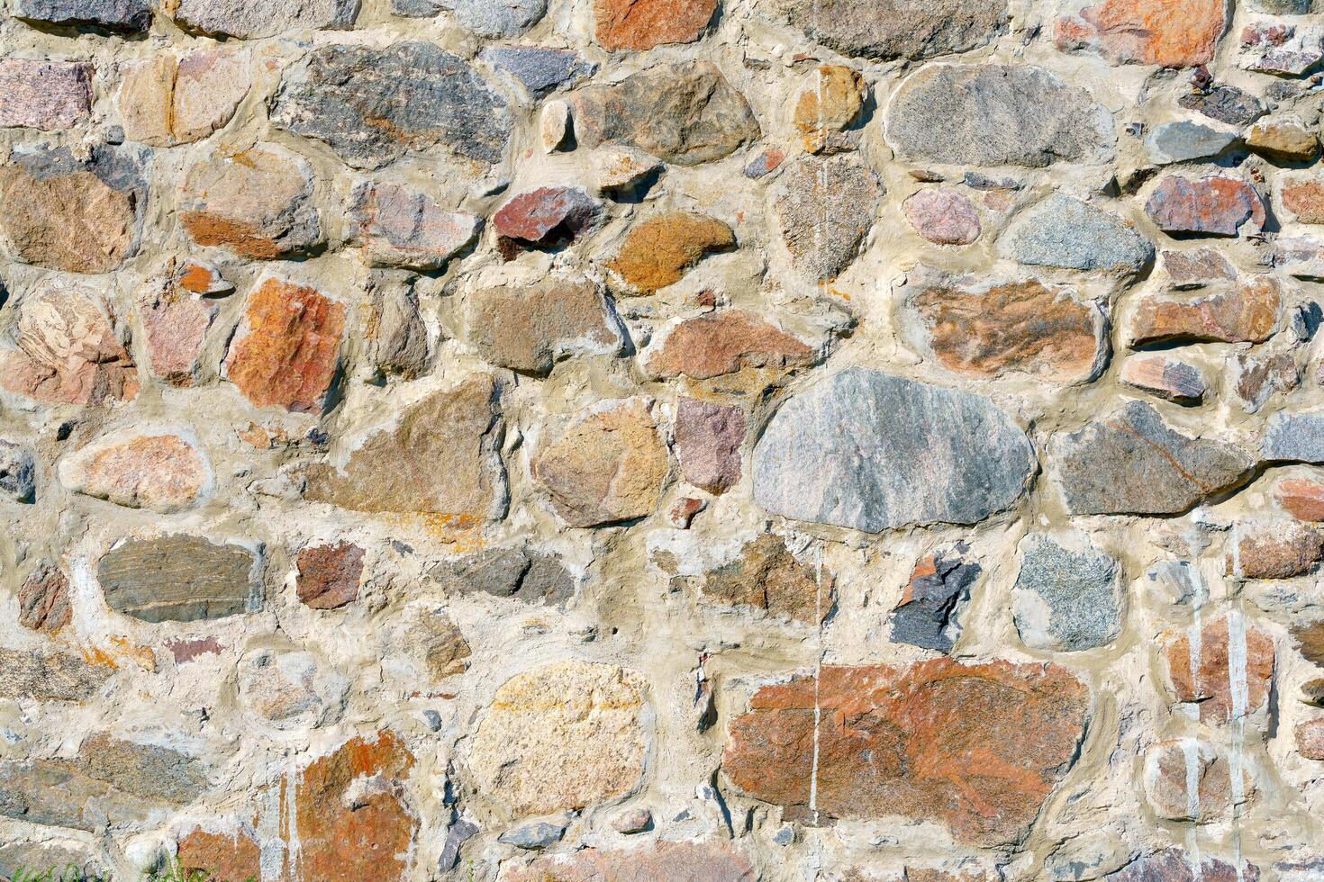 A wall of uneven stones. Vintage building stone background. photo