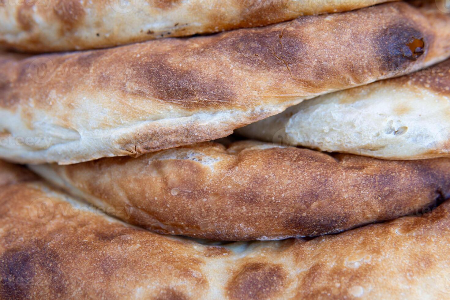 Beveral pieces of flatbread stacked on top of each other. The bread has a golden-brown crust with some darker spots, indicating it has been baked to a crisp texture photo