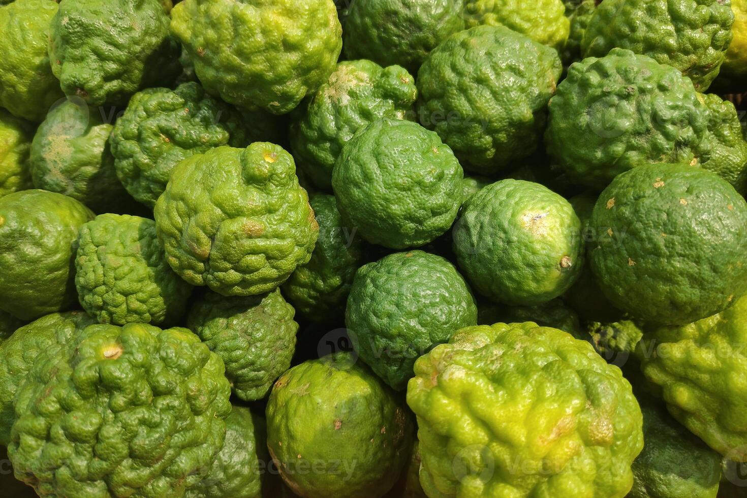 Stack of Kaffir limes on a market stall photo