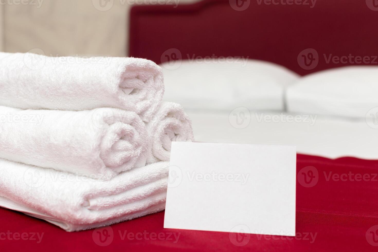 Clean towels on bed at hotel room photo