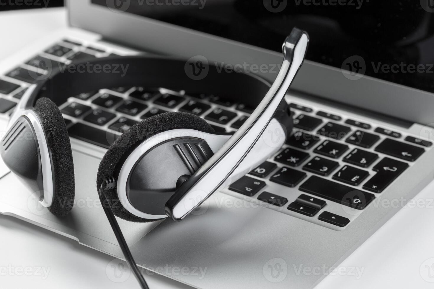 call center support concept. headset on keyboard computer laptop photo