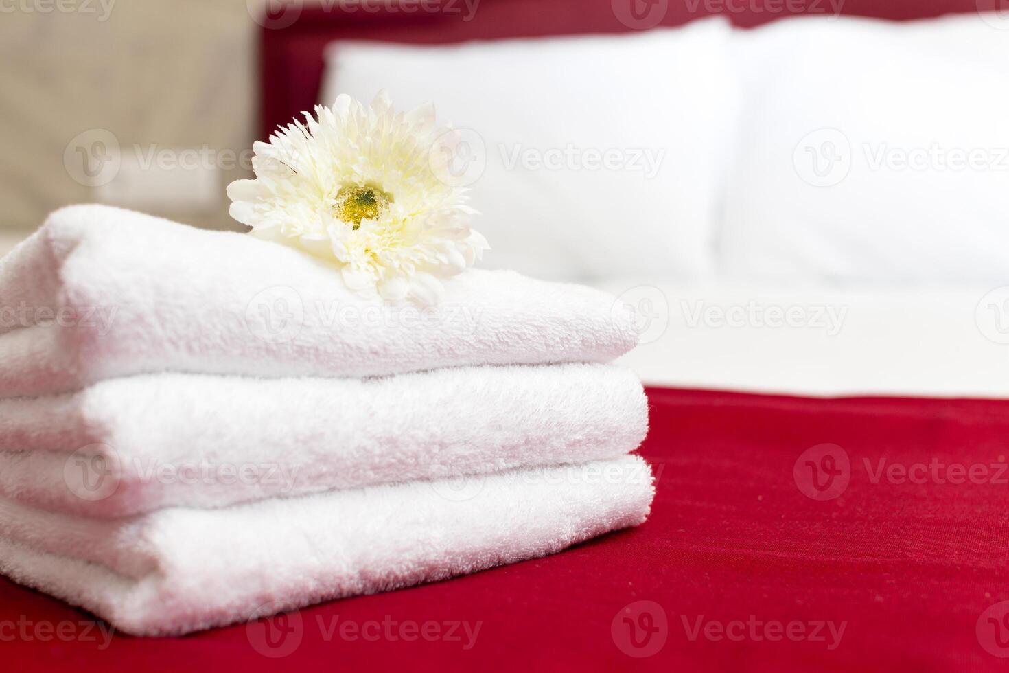 Stack of towels with flower decor in a hotel room photo