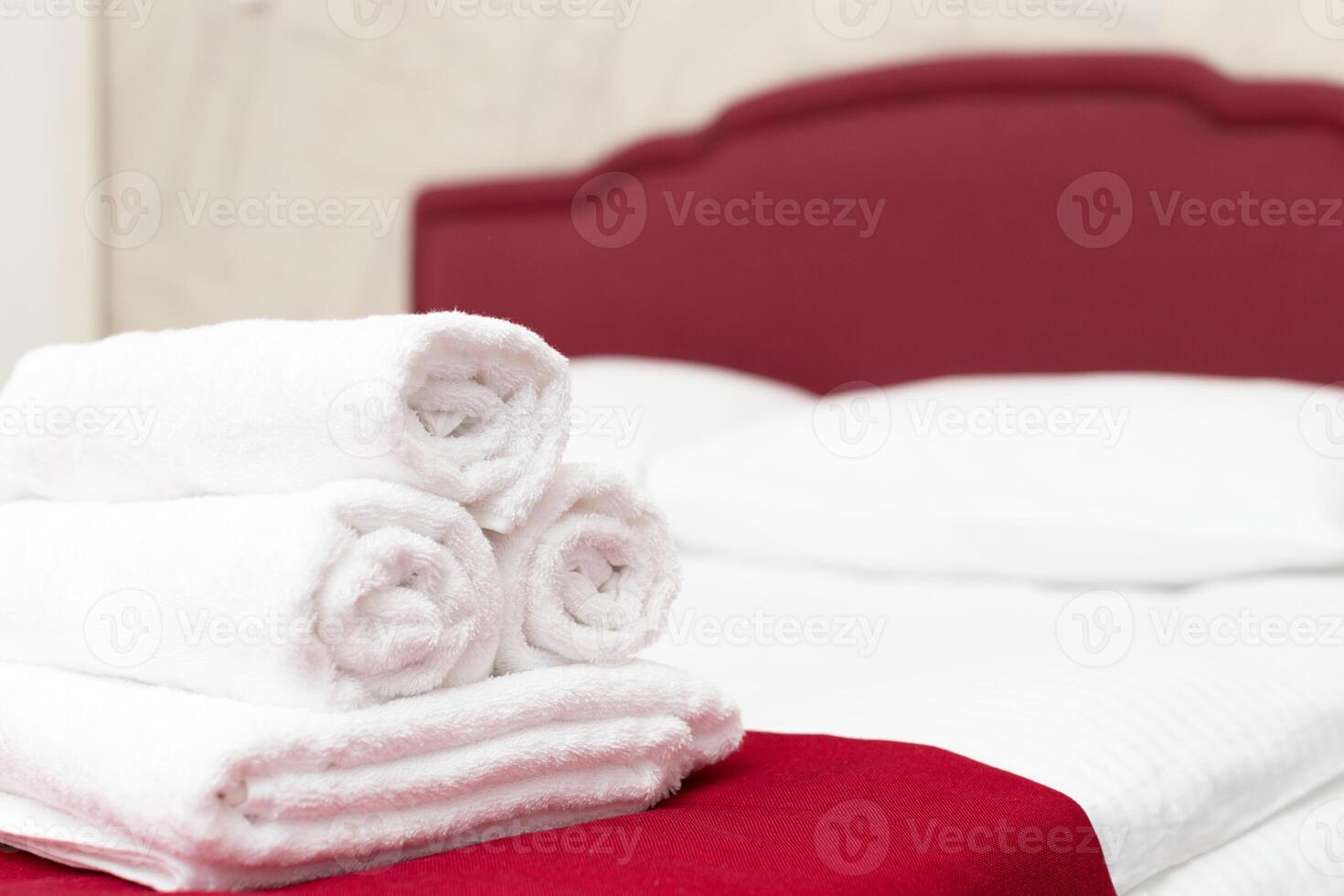 Clean towels on bed at hotel room photo