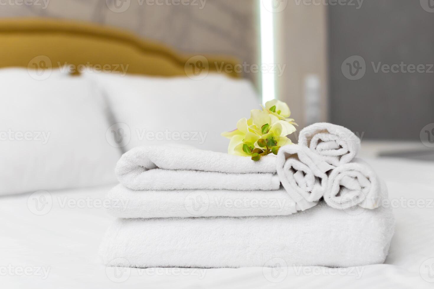 Stack of towels with flower decor in a hotel room photo