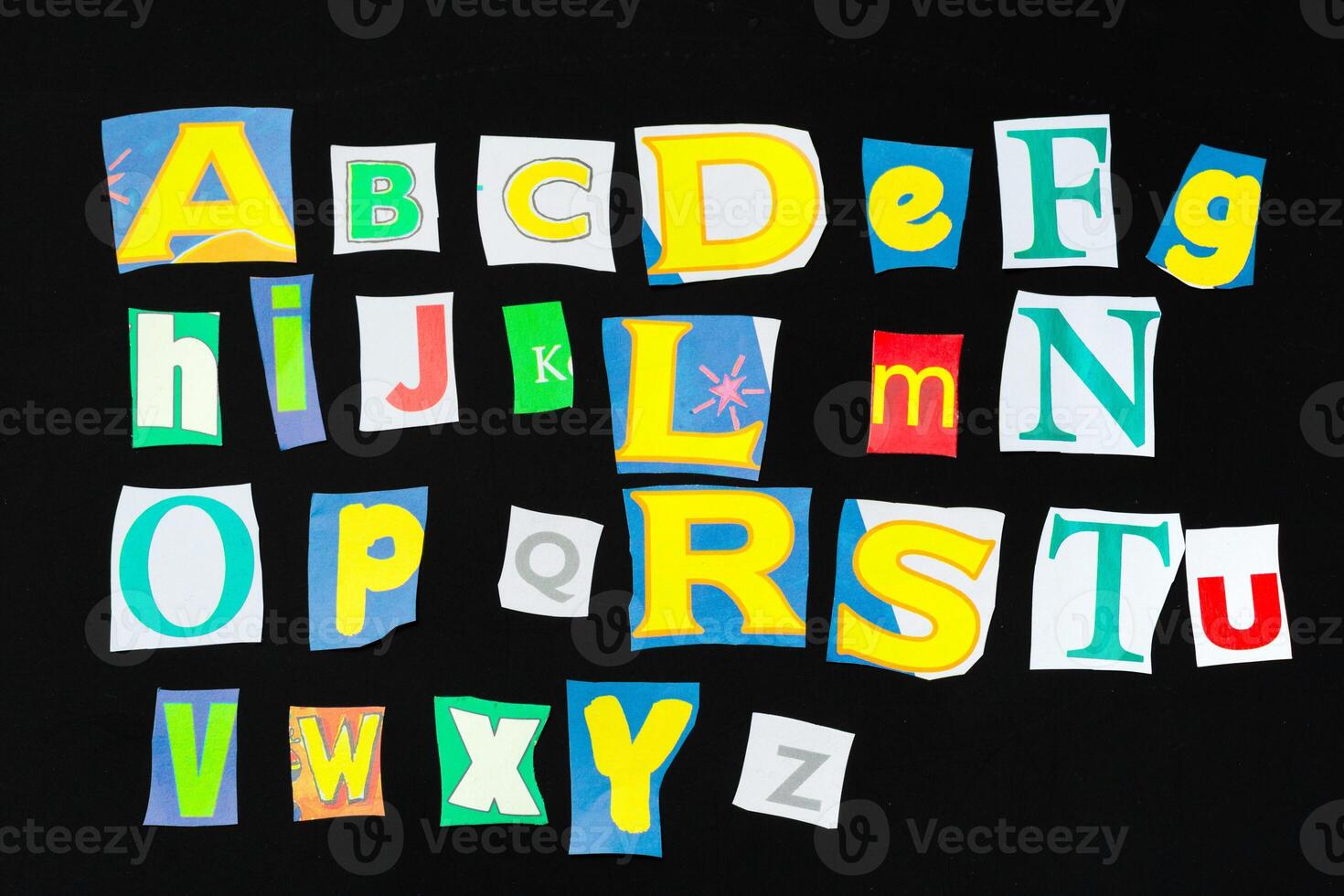 Colorful newspaper alphabet isolated on black photo