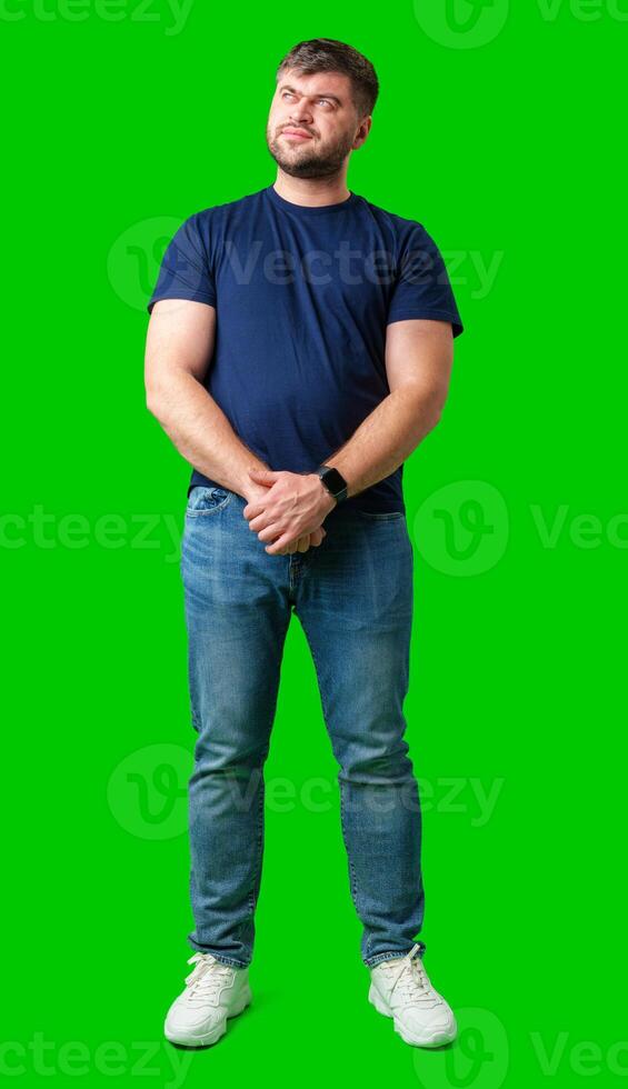 Man standing with a thoughtful expression in a casual outfit against a green background photo