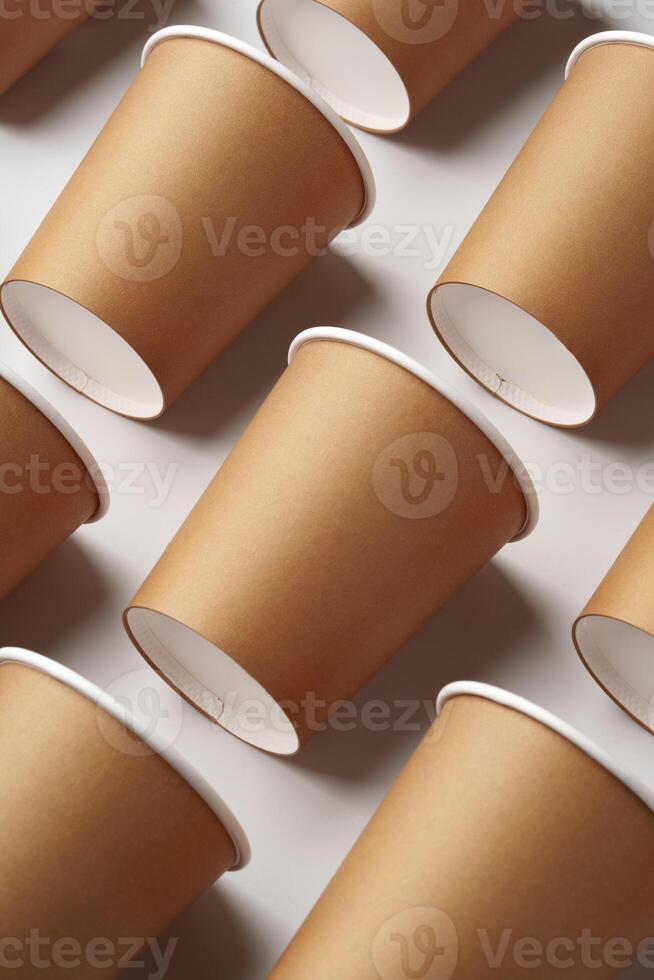 A collection of disposable paper cups arranged in a repeating pattern on a light background photo