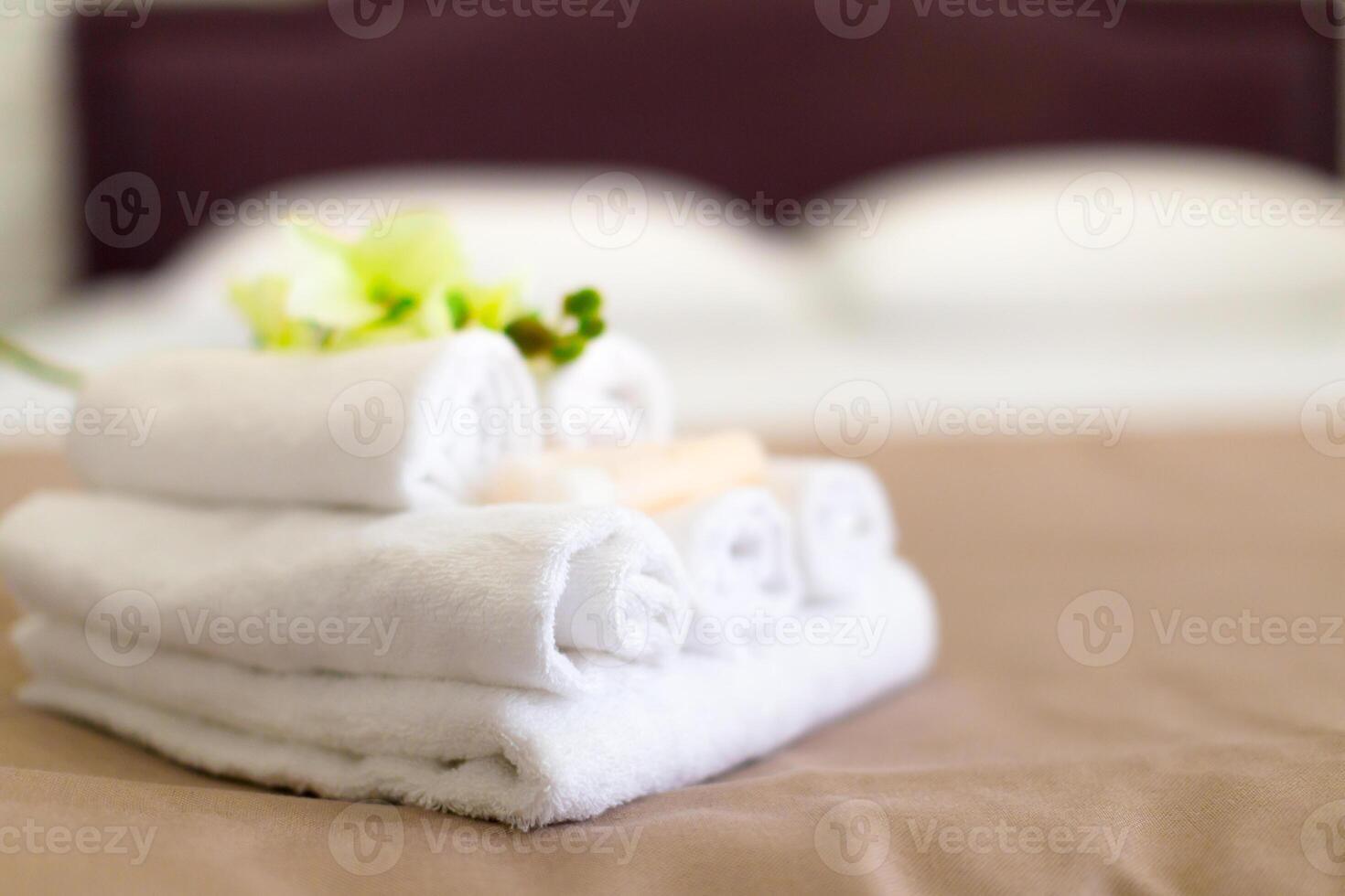 Stack of towels with flower decor in a hotel room photo