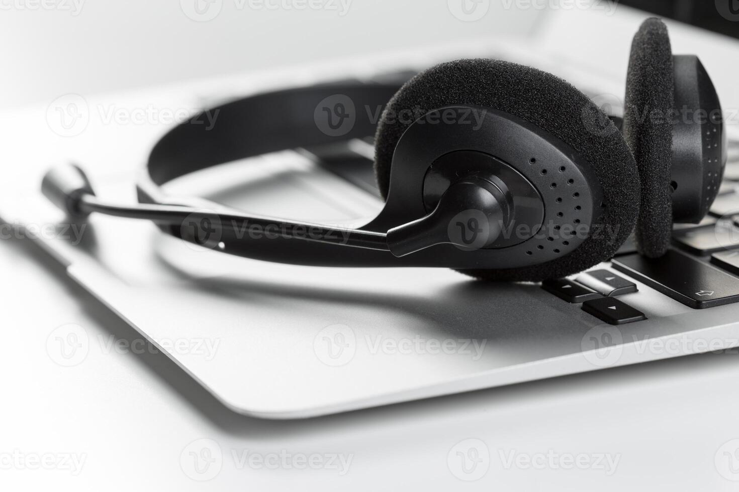 call center support concept. headset on keyboard computer laptop photo
