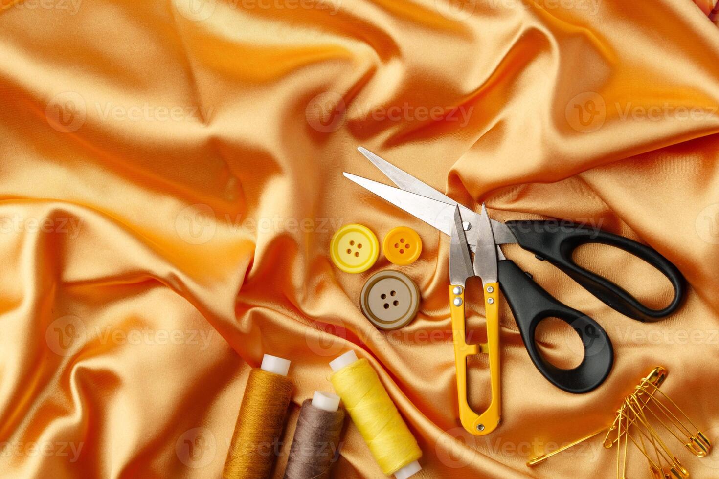 Sewing tools and materials arranged on a luxurious golden fabric background in a creative crafting workspace photo