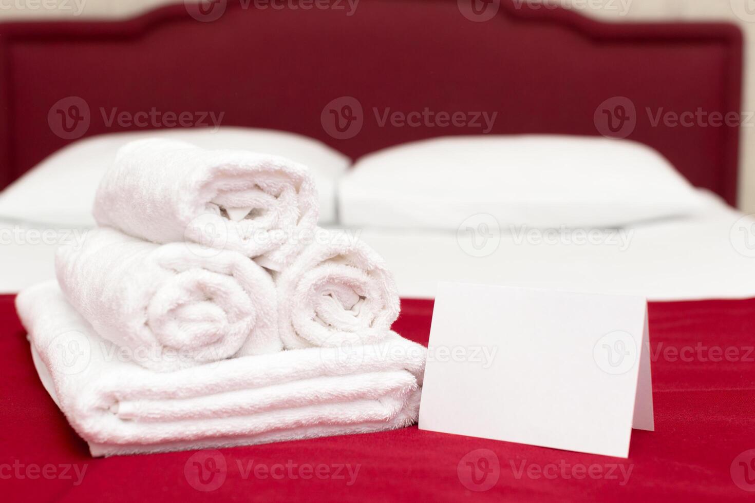 Clean towels on bed at hotel room photo