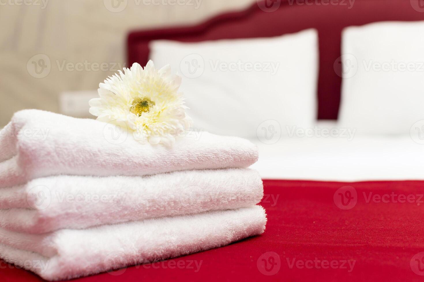 Stack of towels with flower decor in a hotel room photo