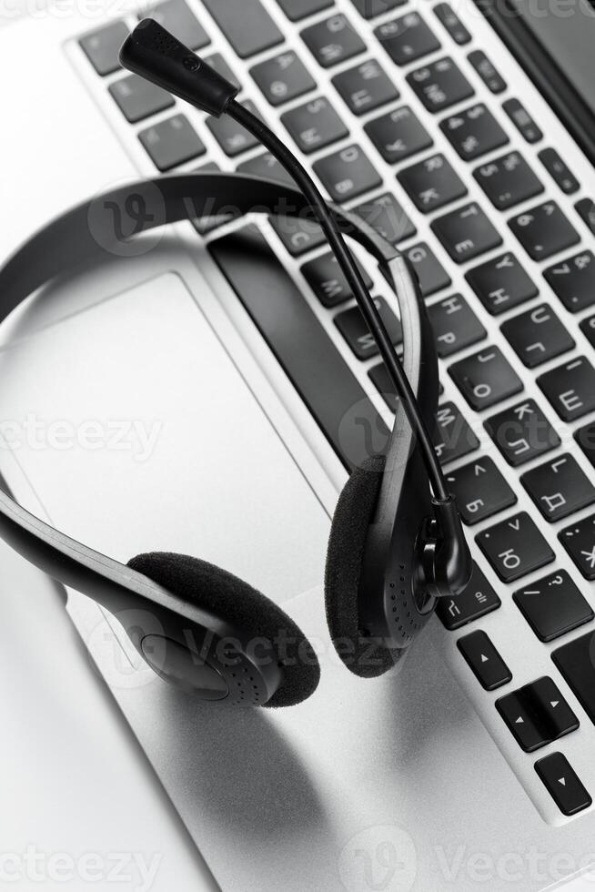call center support concept. headset on keyboard computer laptop photo