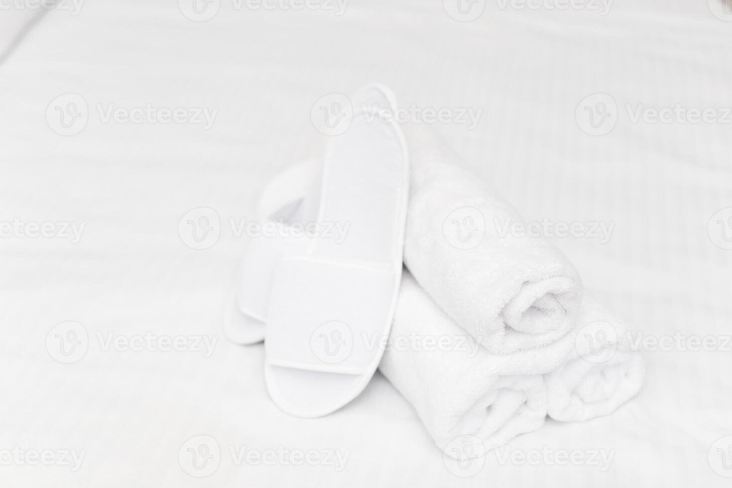 Clean towels on bed at hotel room photo
