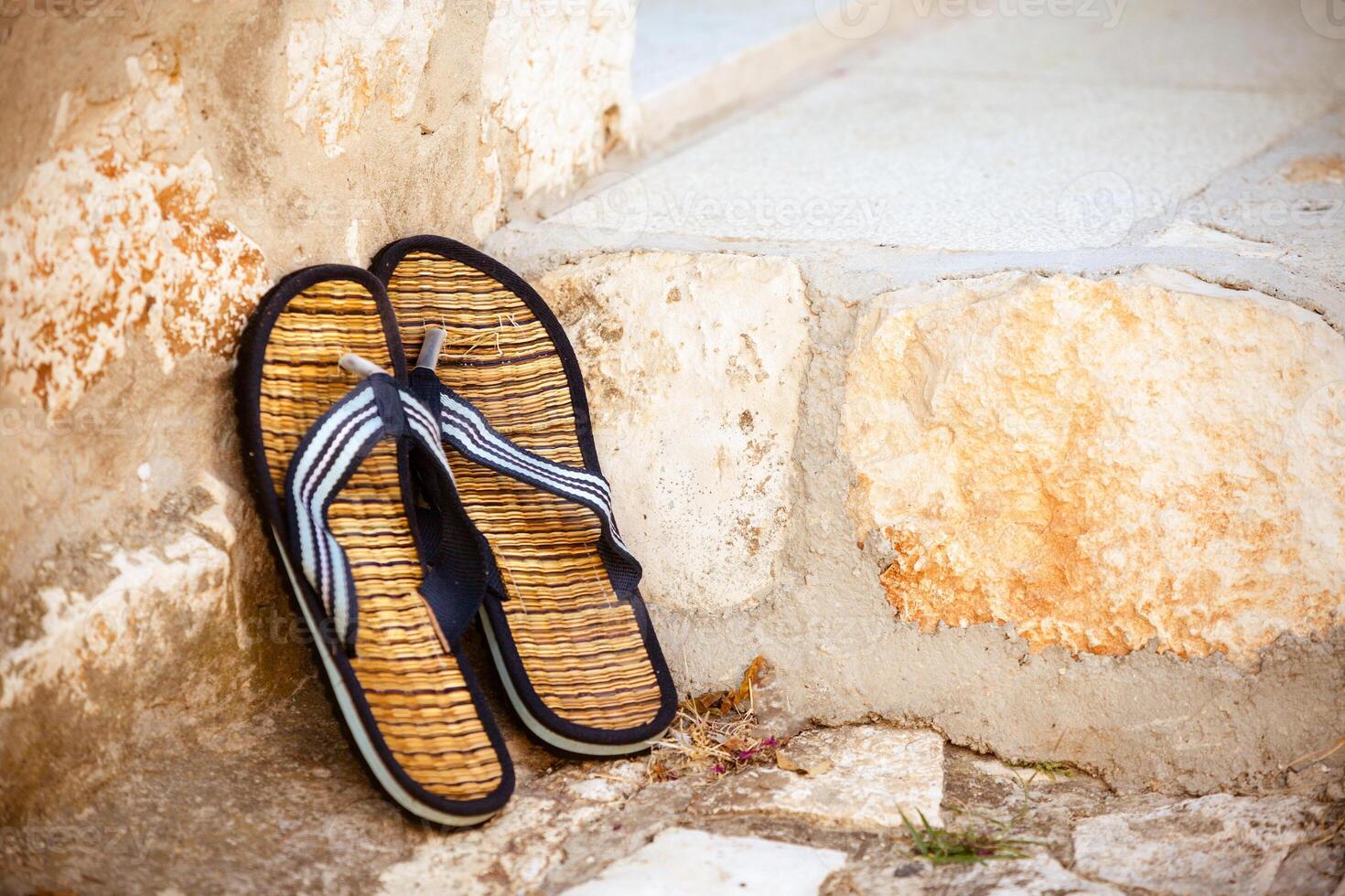 Beach flip-flops on the old wall background photo