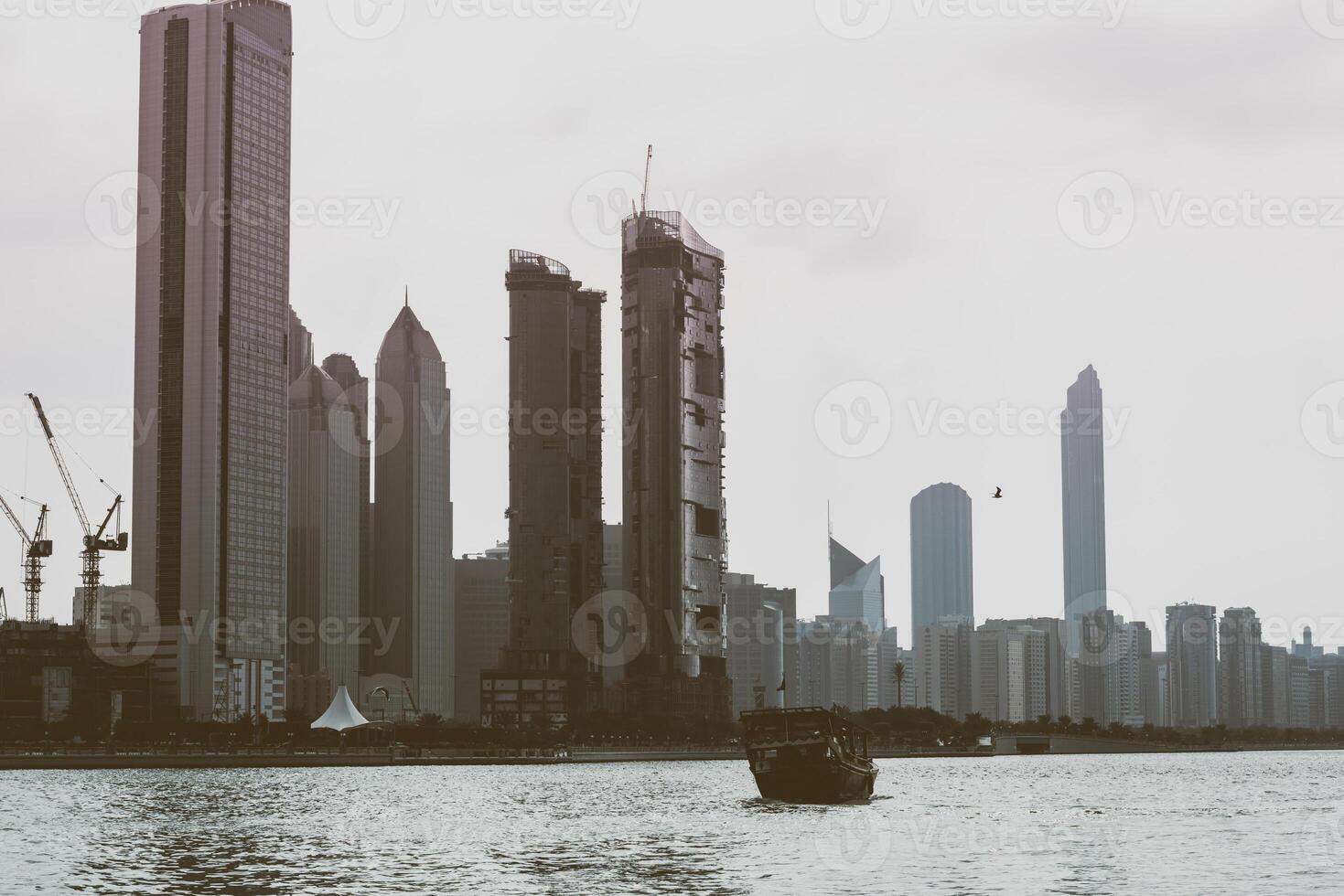 Abu Dhabi buildings skyline with old fishing boat photo
