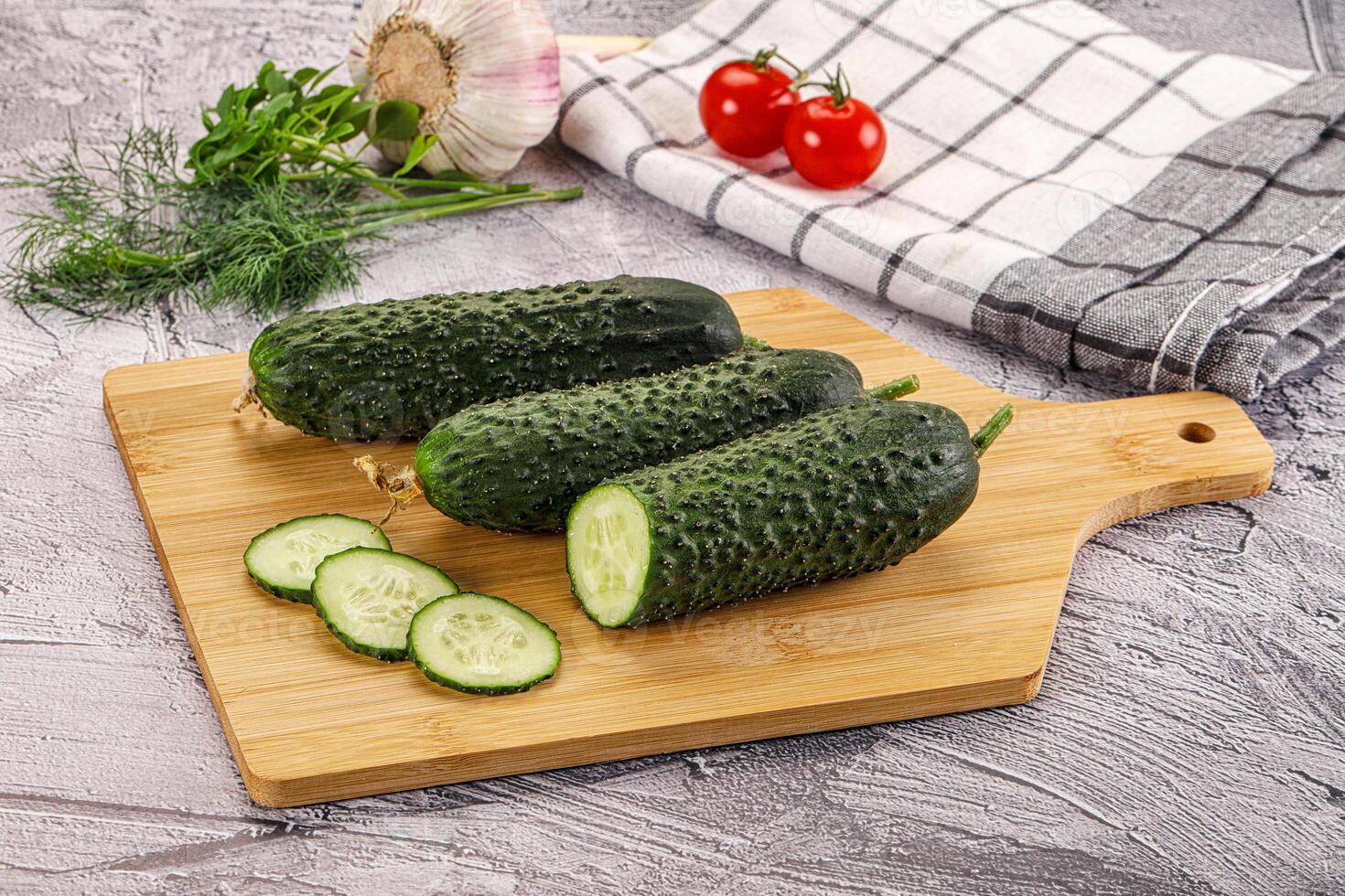 Raw green cucumbers with slices photo