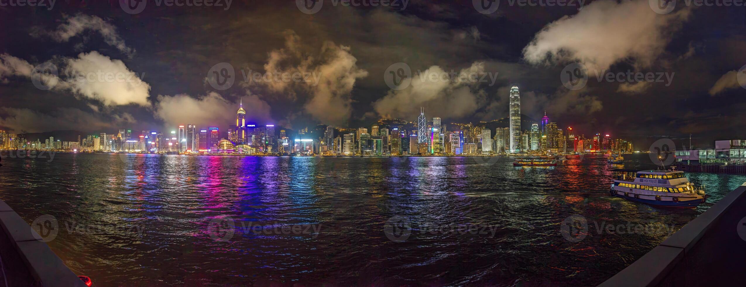 Panoramic nighttime view of illuminated Hong Kong skyline reflected in the water with vibrant city lights photo