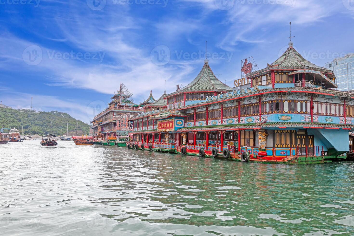 Colorful floating restaurant with intricate Asian architecture on a scenic waterfront under a vibrant sky photo