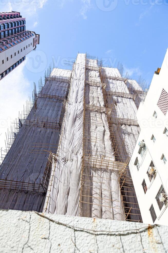 Dense urban architecture in Hong Kong with tightly packed high-rise buildings under a bright sky photo
