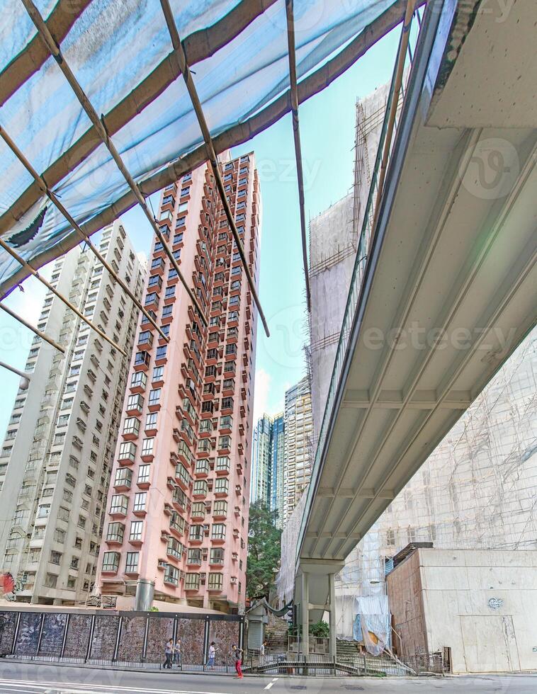 Dense urban architecture in Hong Kong with tightly packed high-rise buildings under a bright sky photo