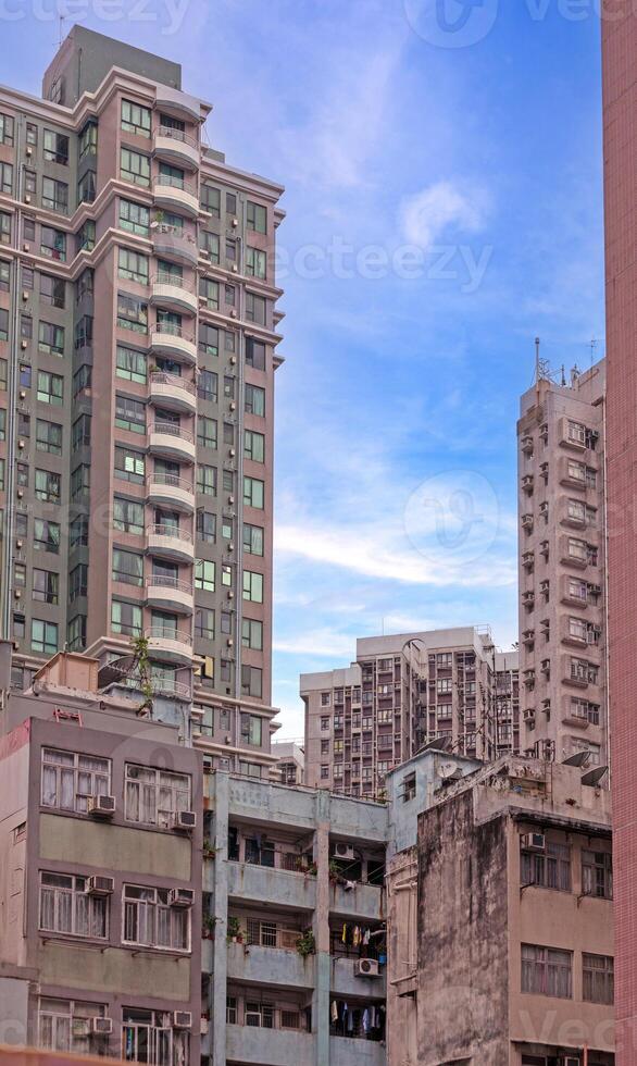 Dense urban architecture in Hong Kong with tightly packed high-rise buildings under a bright sky photo