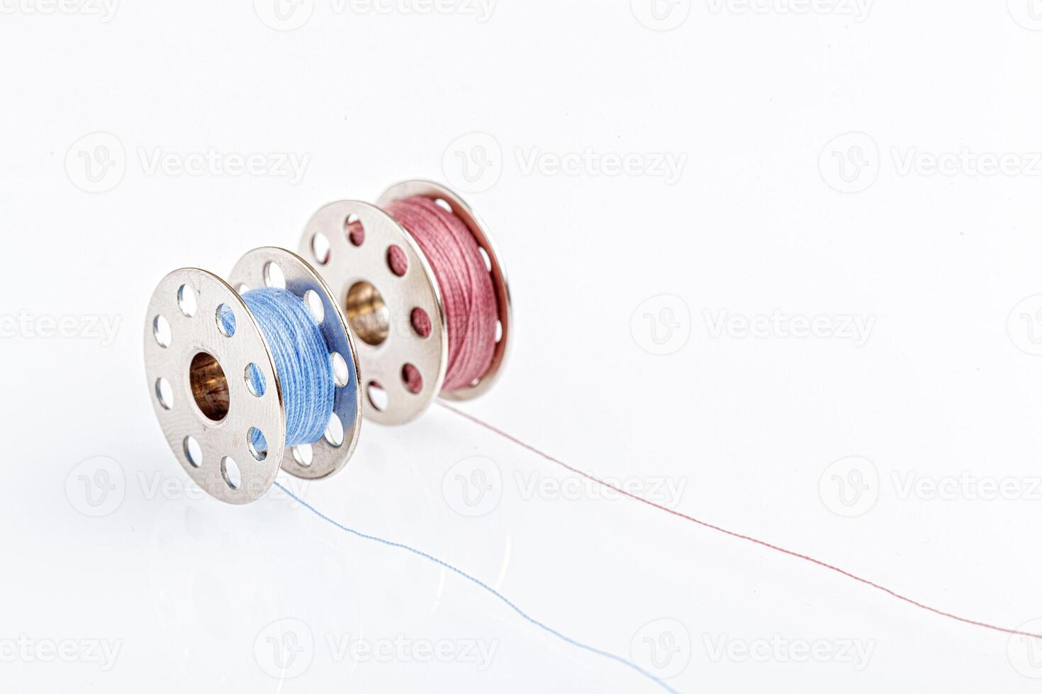 spools of blue and pink thread on a white background photo