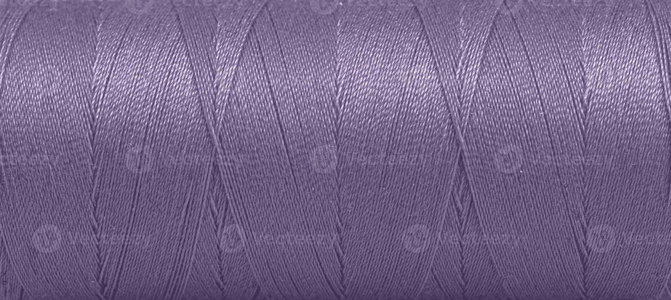 Texture of threads in a spool of purple color on a white background photo
