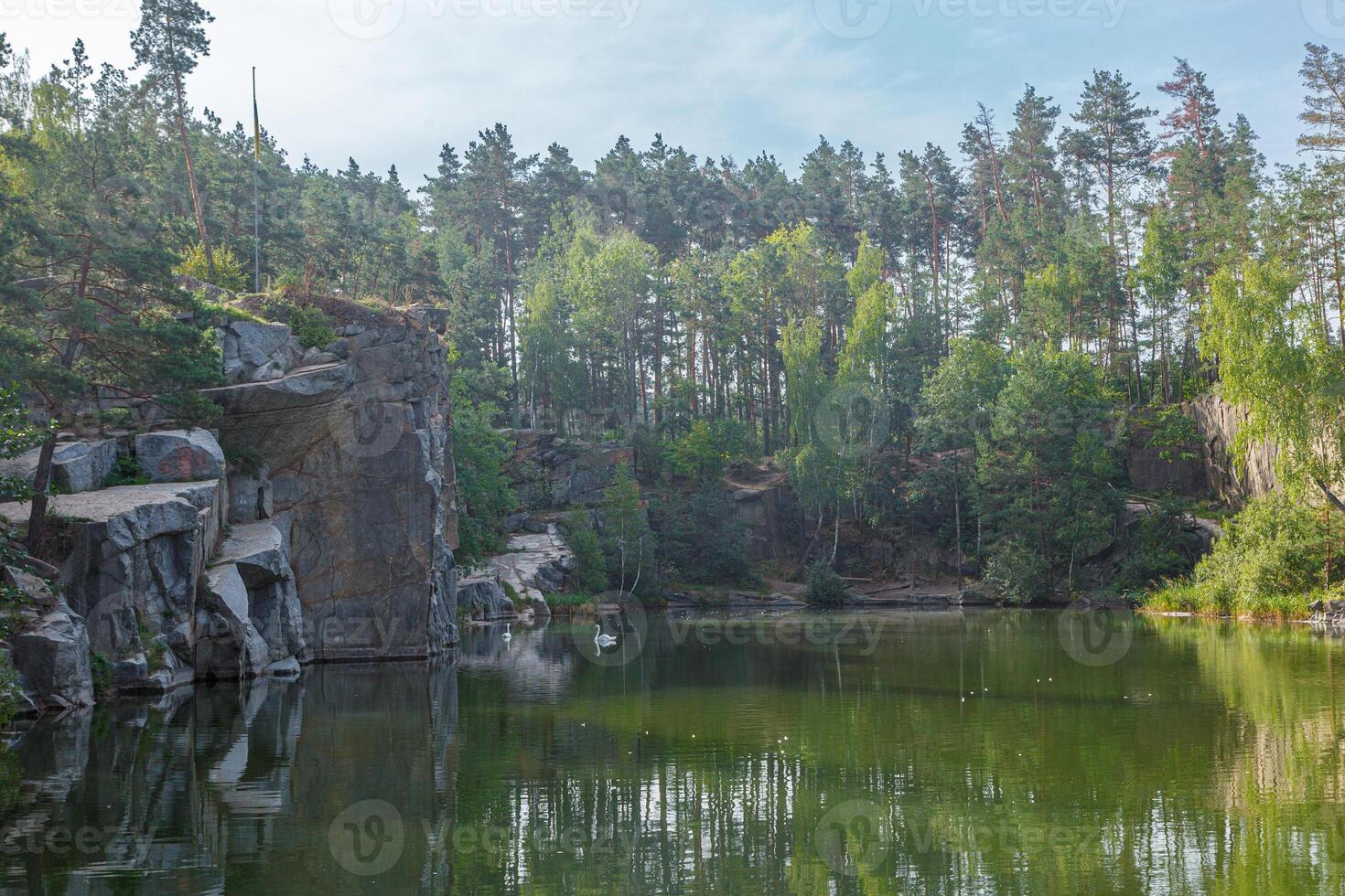 beautiful lake with a canyon on which swans swim with a blue sky photo