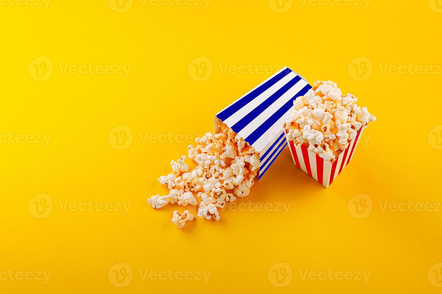 Glass with popcorn on a yellow background photo